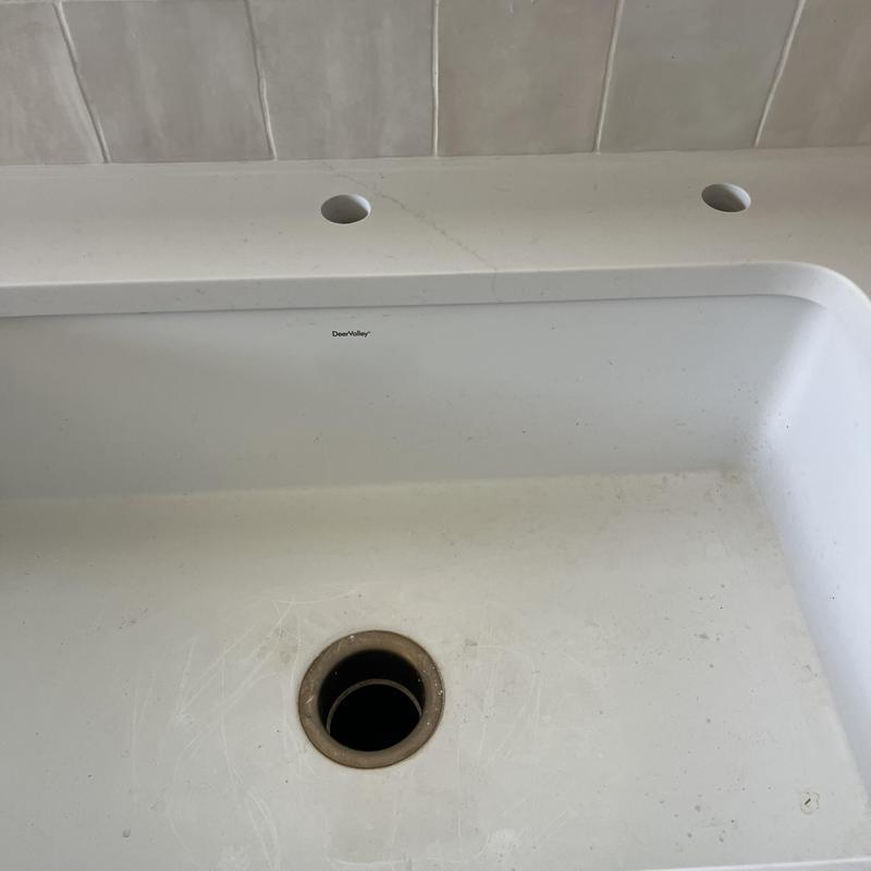 Kitchen sink with faucet and disposal holes in countertop