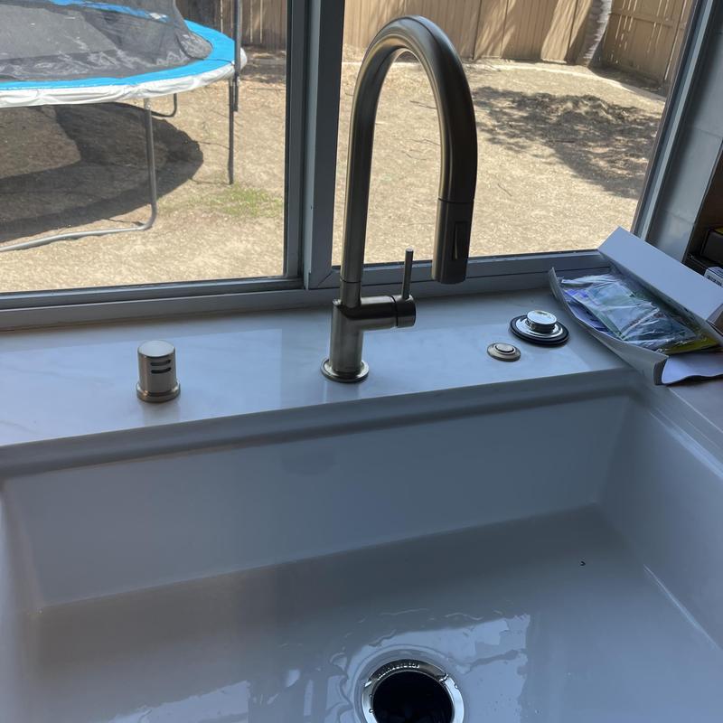 Kitchen faucet with soap dispenser on white sink