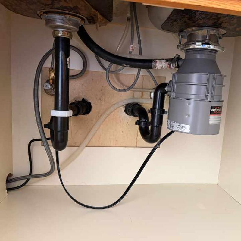 Evergrind garbage disposal and sink drain pipes under cabinet