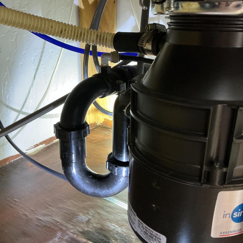Garbage disposal drain tee and pipes under kitchen sink