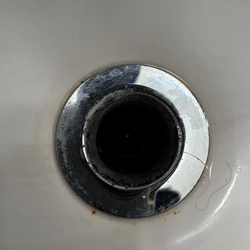 Sink drain opening with chrome flange and debris
