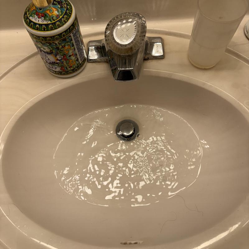 Bathroom sink drain with flowing water and faucet