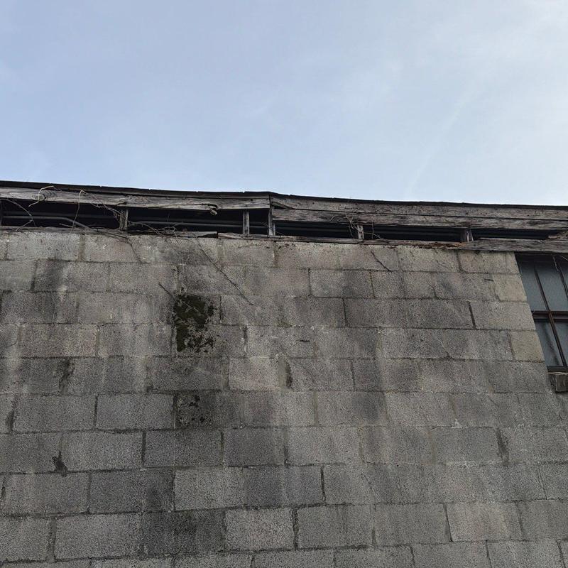 Roof flashing with wood rot and damage on wall