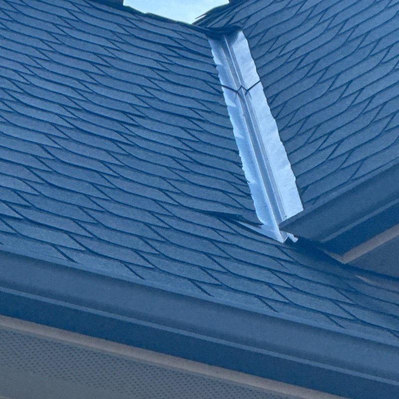 Asphalt shingles with metal flashing on roof corner