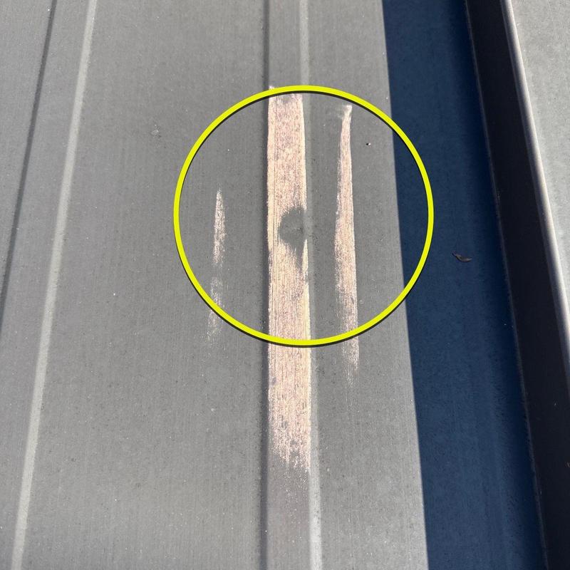 Metal roof panel hail damage with paint scratches