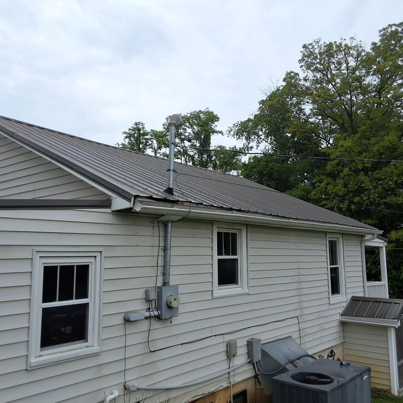 Slate gray metal roof with ventilation pipe and siding Slate gray metal roof with ventilation pipe and siding