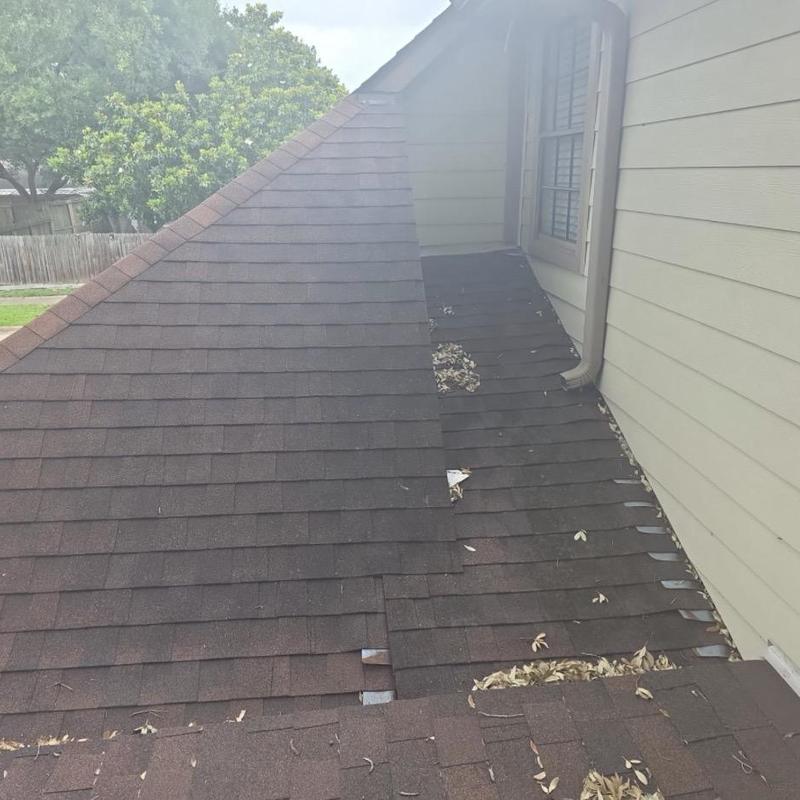 Asphalt shingle roof with debris in roof valley