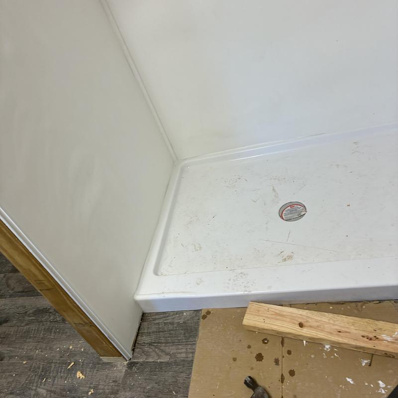Shower pan installation with drain in utility room