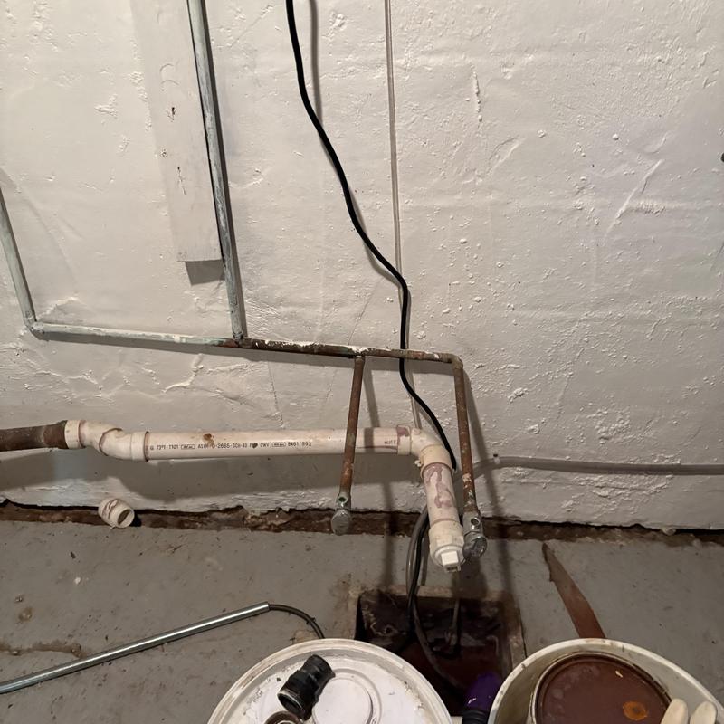 PVC drainage pipe with rusted support brackets in basement PVC drainage pipe with rusted support brackets in basement