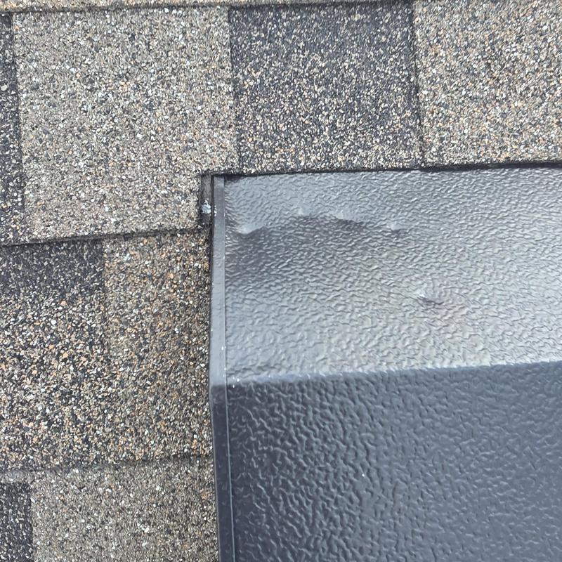 Roof shingles with hail impact damage near metal flashing