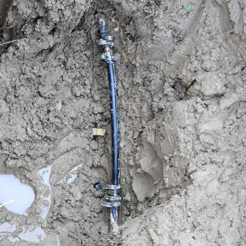 Copper water main spot repair with clamps in muddy excavation Copper water main spot repair with clamps in muddy excavation