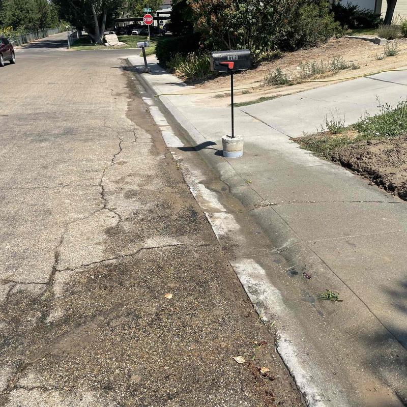 Copper water main leak with water on street curb Copper water main leak with water on street curb