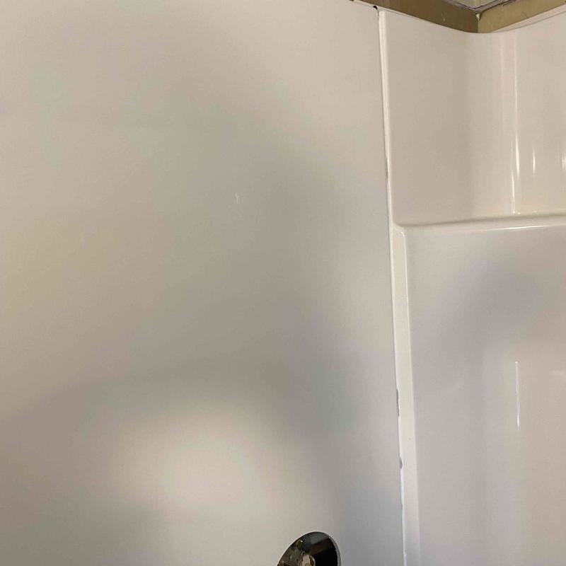 Shower enclosure corner with faucet handle installed