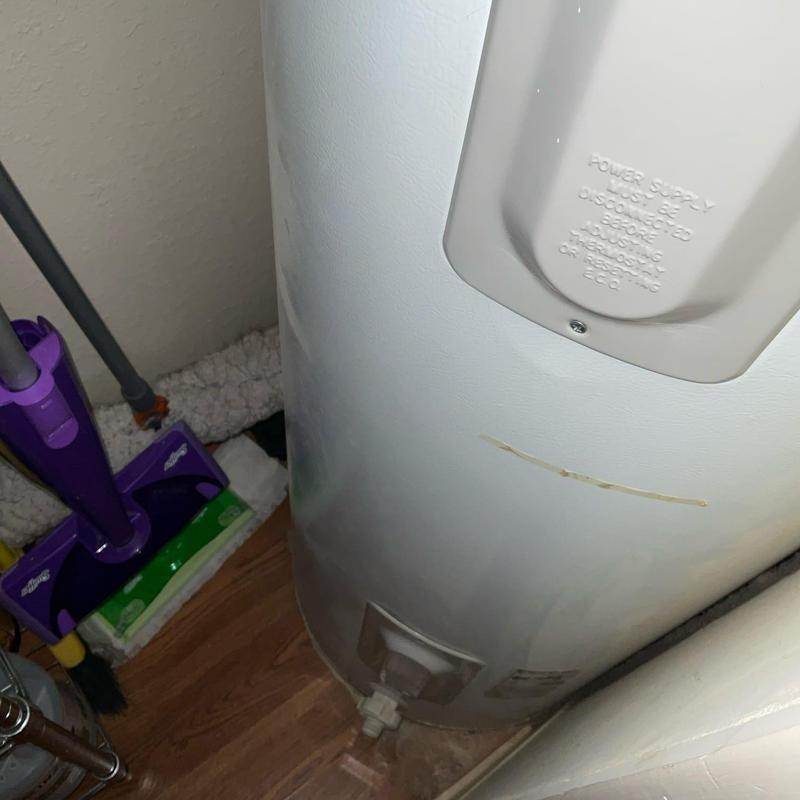 Water heater tank exterior showing minor wear near base Water heater tank exterior showing minor wear near base