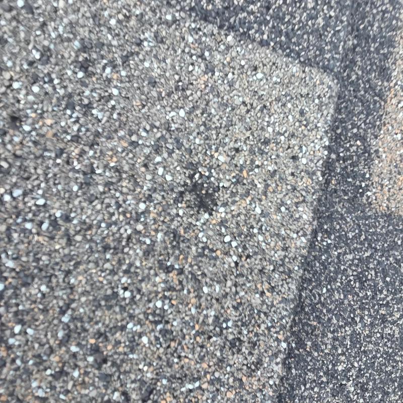 Asphalt roofing shingles with hail damage close-up