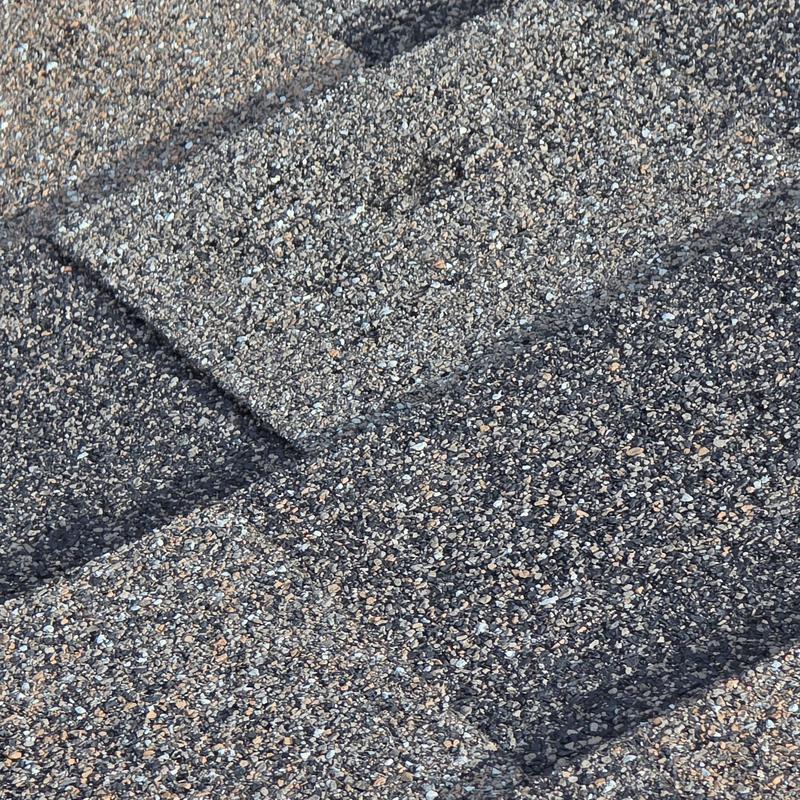 Asphalt roof shingles with hail damage close-up