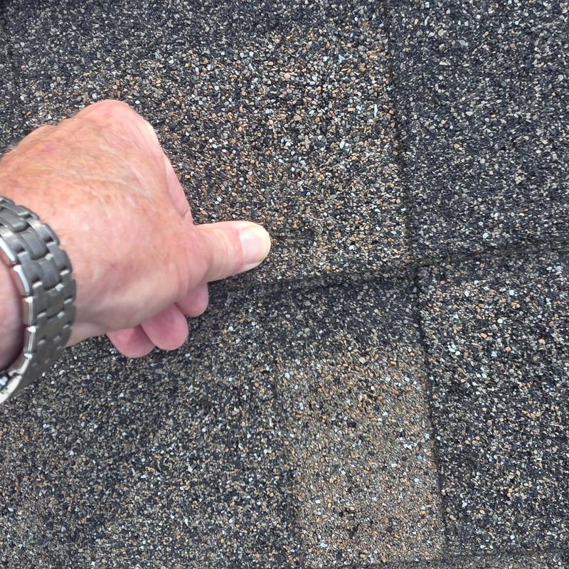 Asphalt roof shingles showing hail damage assessment