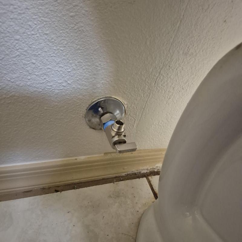 Quarter turn angle stop valve near toilet base