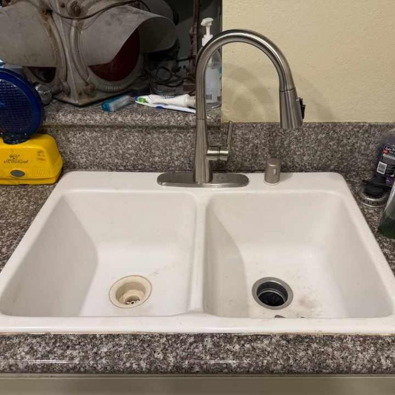 Kitchen sink faucet and drain assembly on granite countertop