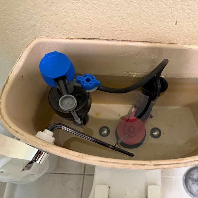 Toilet tank fill valve and flush valve assembly inside tank