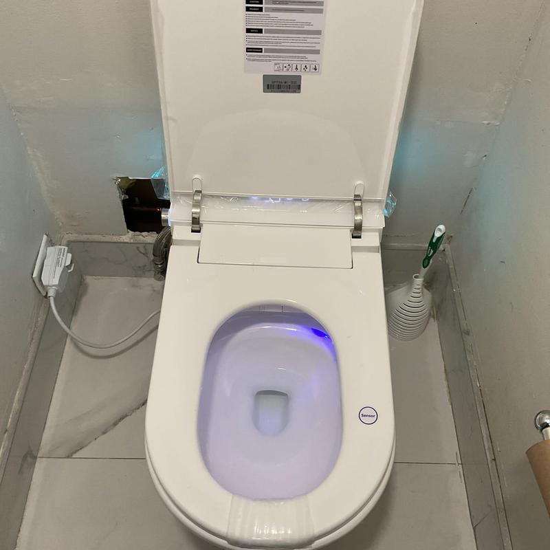 Smart toilet installation with sensor light on tiled floor