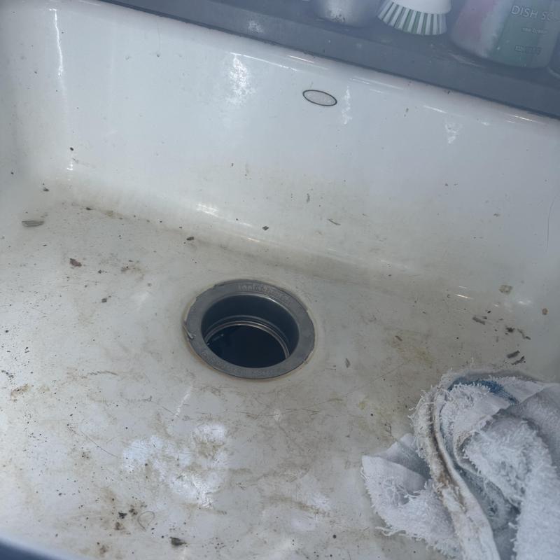 Kitchen sink drain opening with debris and cleaning rag