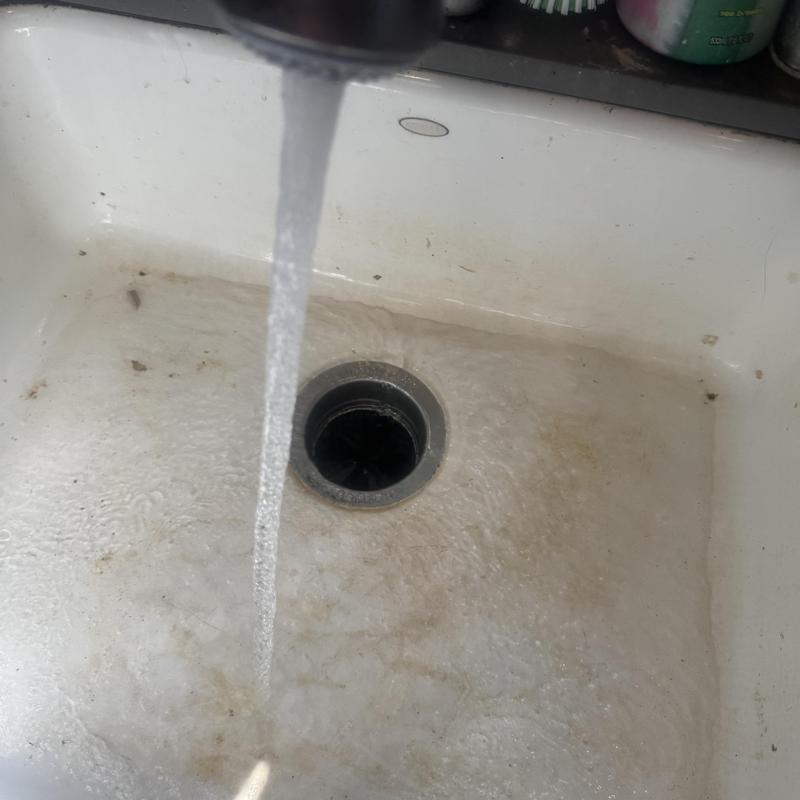 Kitchen sink drain with flowing water and debris