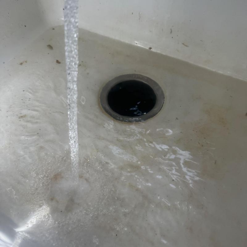 Kitchen sink drain with flowing water in basin