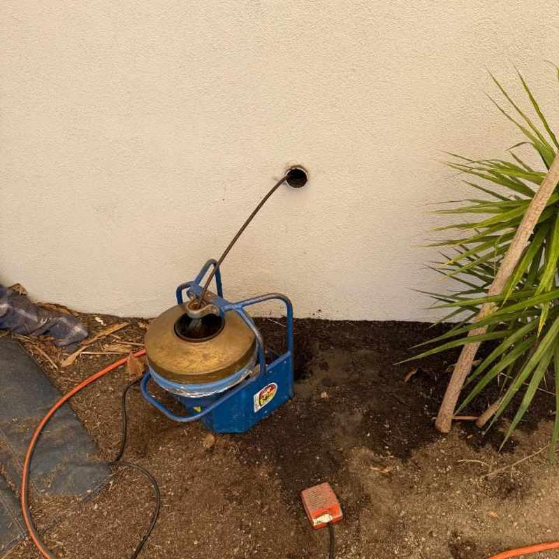 Drain cleanout pipe with cleaning machine in yard