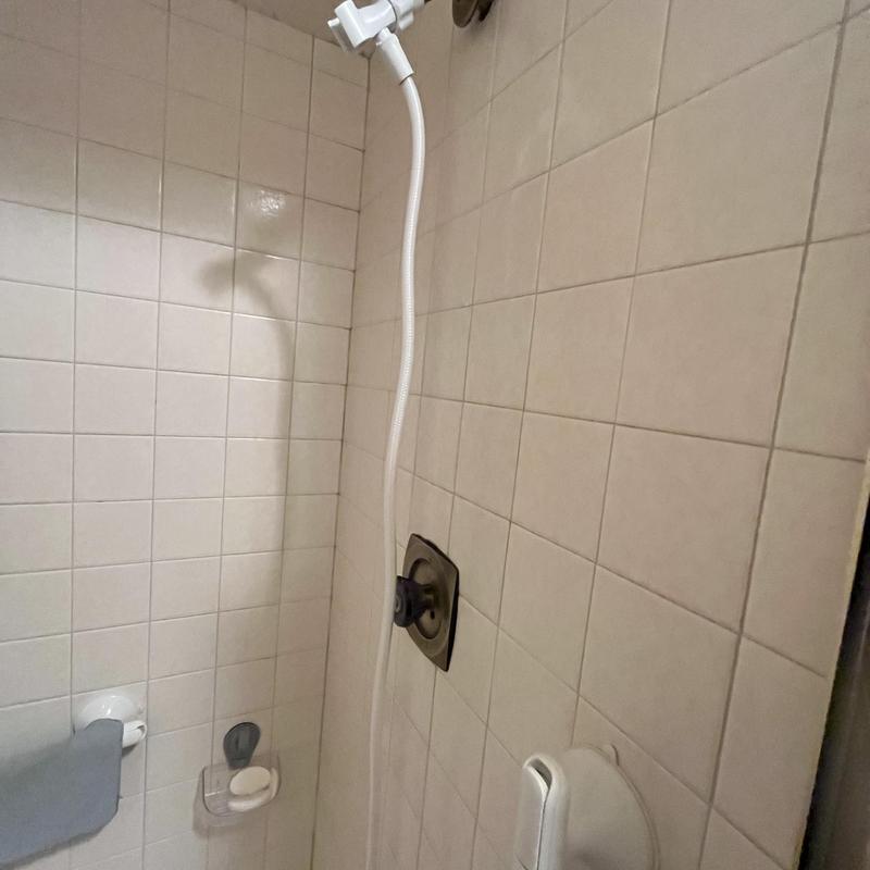Shower valve replacement with gold trim in tiled shower