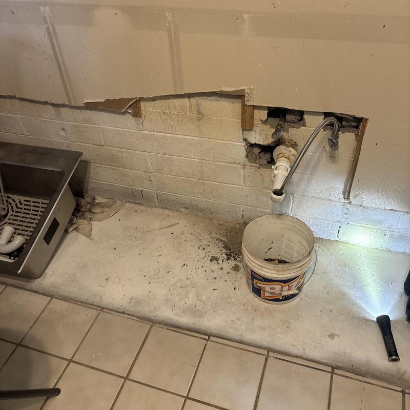 Sink drain pipe with wall access cutout in basement