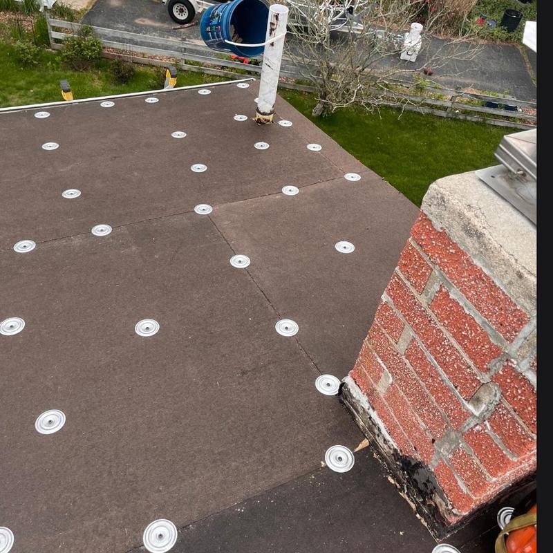 Flat roof with fasteners near chimney brickwork Flat roof with fasteners near chimney brickwork