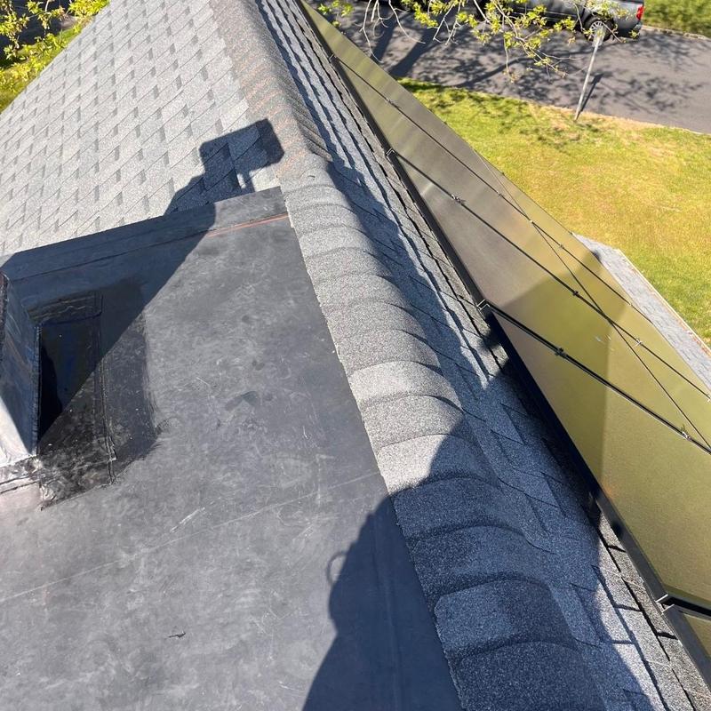 Roof shingles and rubber flat roof edge with solar panels Roof shingles and rubber flat roof edge with solar panels