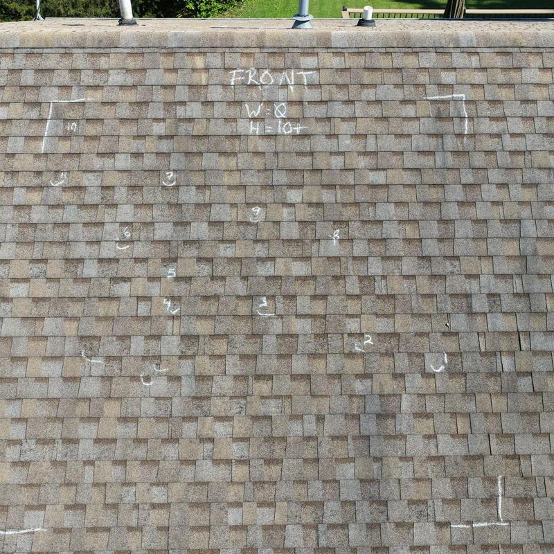 Asphalt shingle roof with hail damage marked for inspection Asphalt shingle roof with hail damage marked for inspection