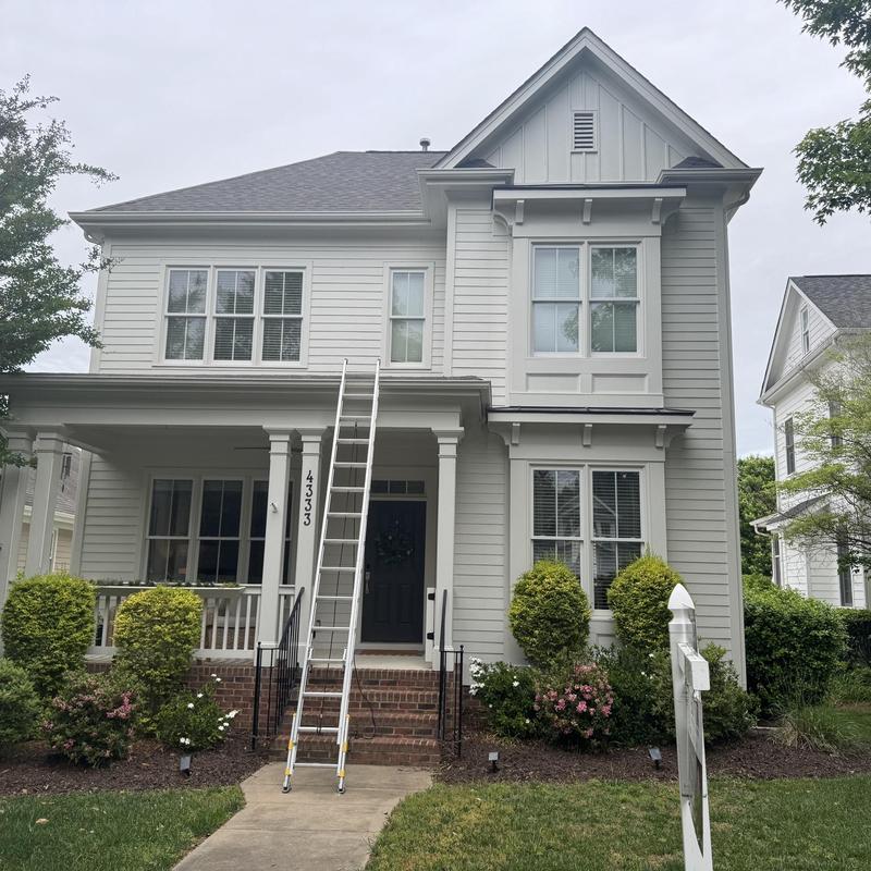 Asphalt shingle roof with ladder on two-story home