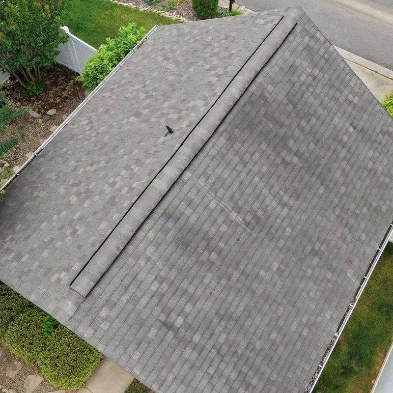 Asphalt shingle roof with ridge vent in residential yard