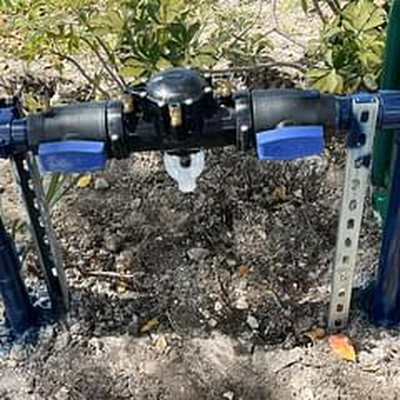 Backflow prevention assembly with valve handles installed outdoors