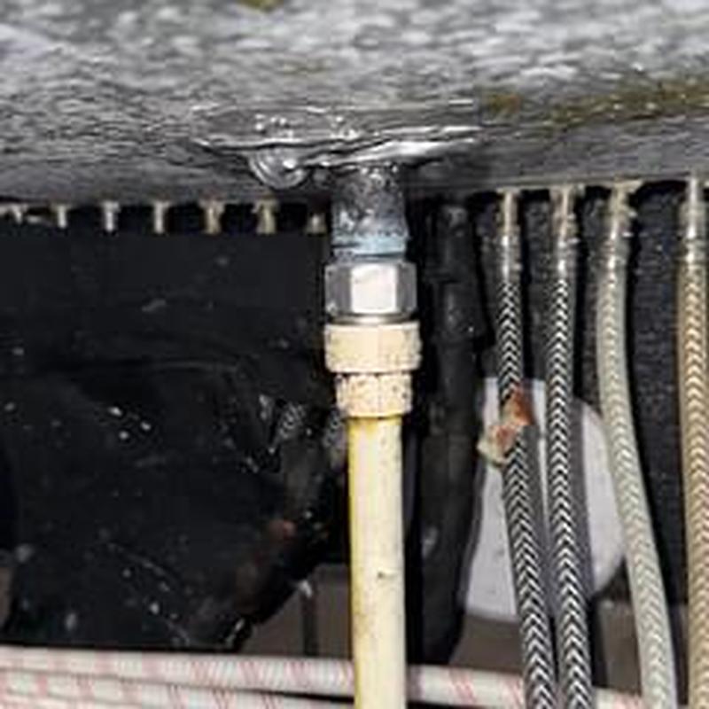 PVC pipe connection under ice bin with fittings and hoses
