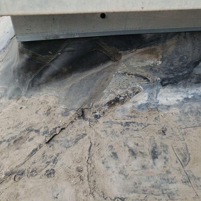 Modified bitumen roof showing wear and damage