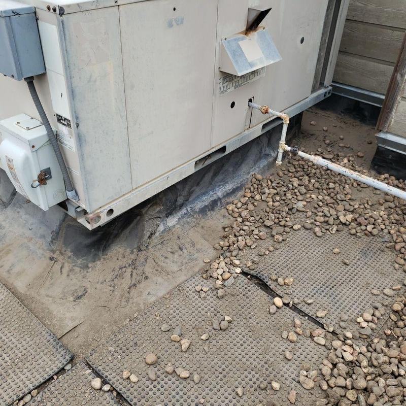 Rooftop HVAC unit with gas piping and gravel ballast