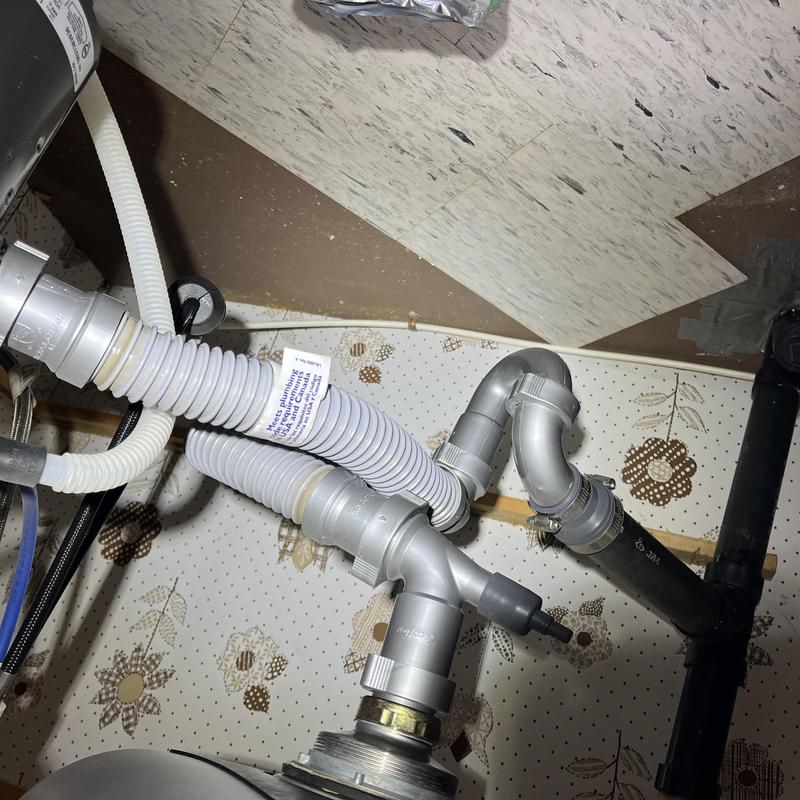 PVC drainage tubing and fittings under kitchen sink