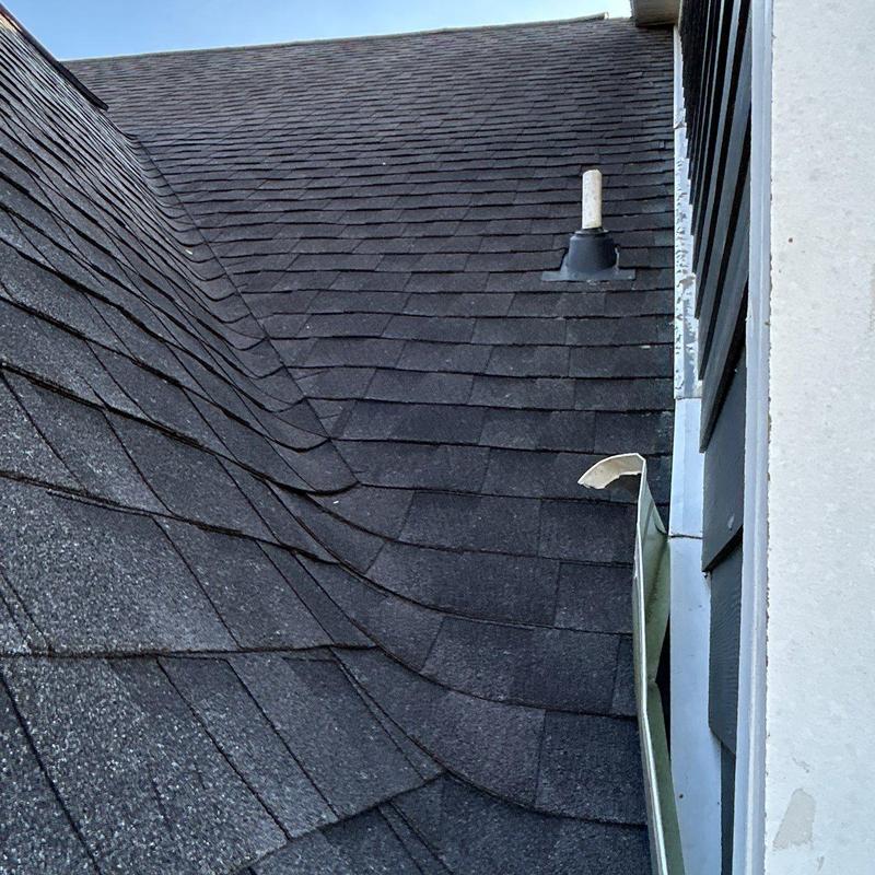 Asphalt shingles with hail damage and roof vent pipe