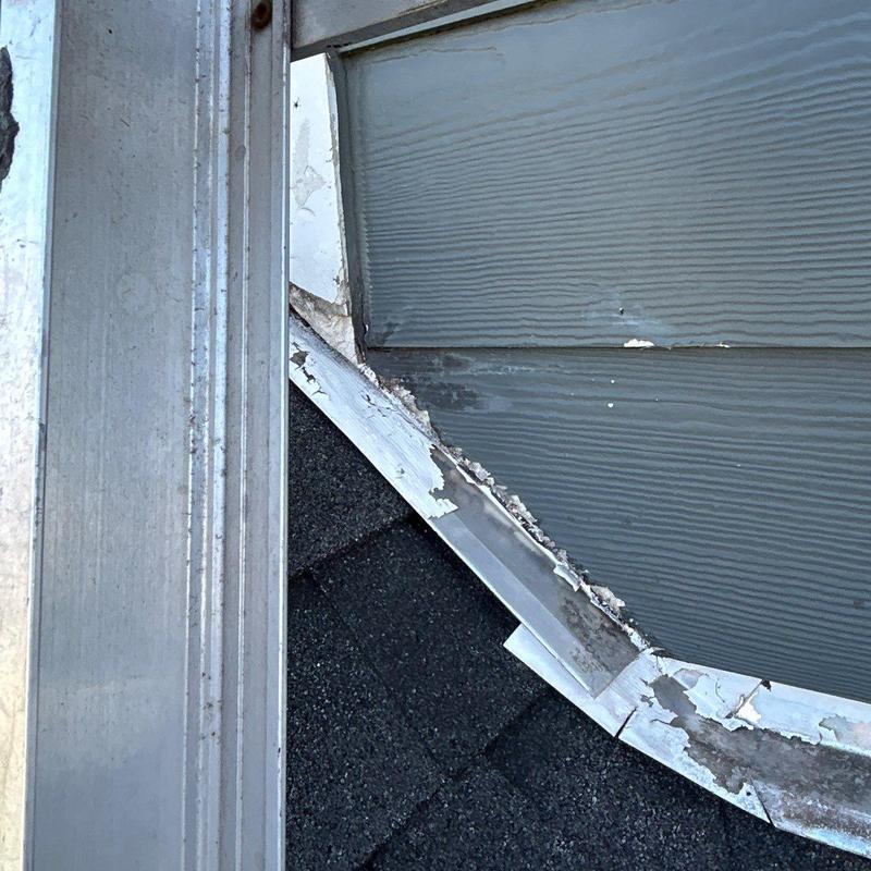 Roof flashing with peeling paint and wear damage