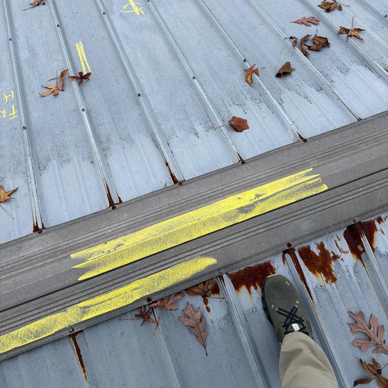 Metal roof panels with rust and hail damage markings