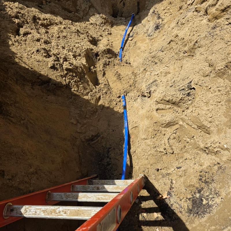 Water service line with blue piping in trench