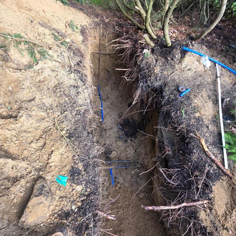 Water service line trench excavation with blue piping