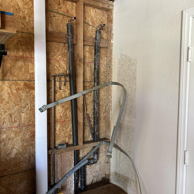 Water heater connection pipes and wall opening in garage