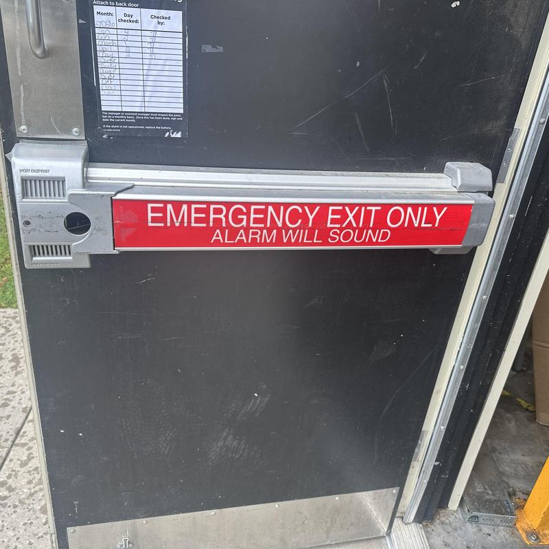 Exit device with alarm bar on emergency door installation Exit device with alarm bar on emergency door installation