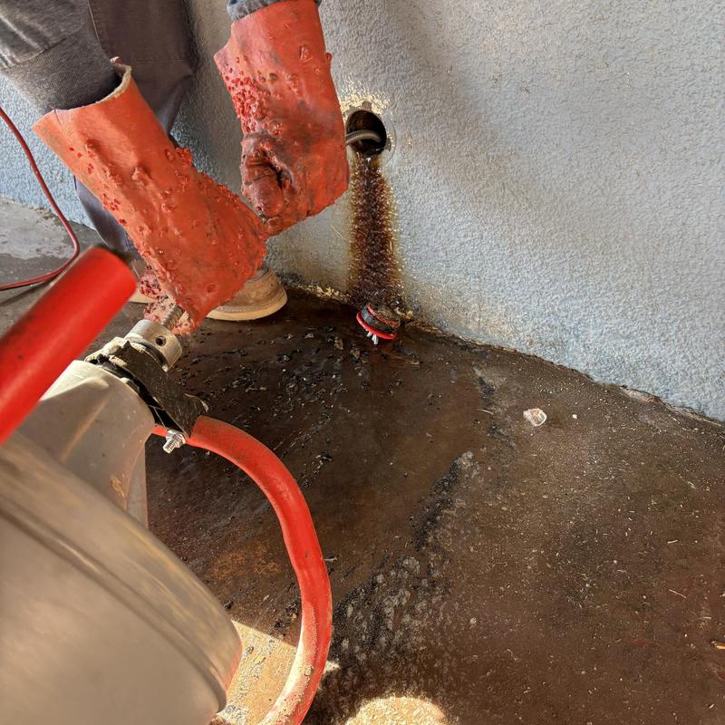 Sewer machine cable clearing grease from drain line