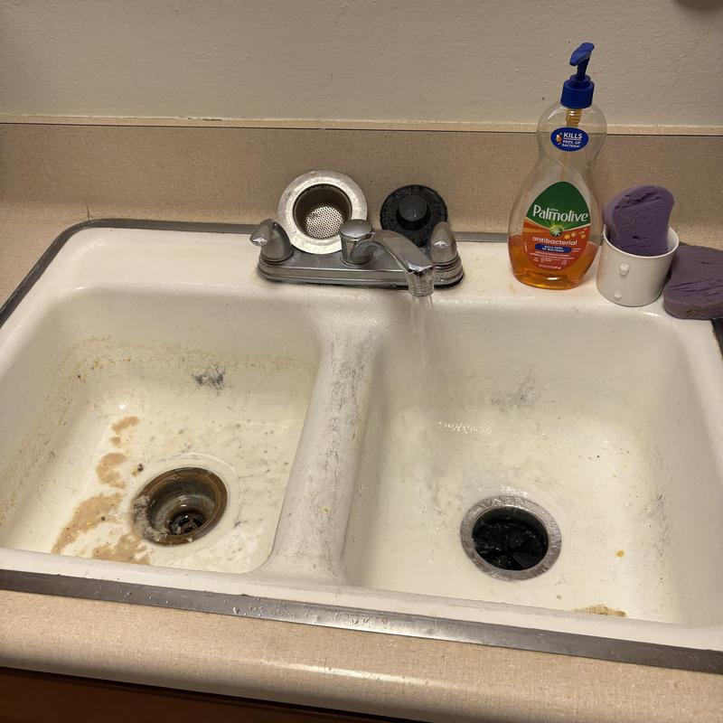 Kitchen sink drain with running water and soap bottle